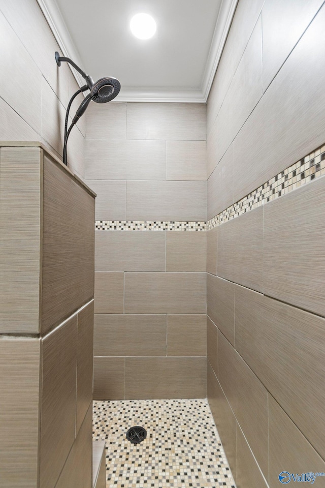 bathroom featuring tiled shower and crown molding