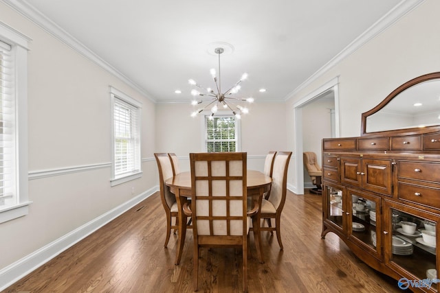 dining space with dark wood-type flooring, plenty of natural light, a notable chandelier, and ornamental molding