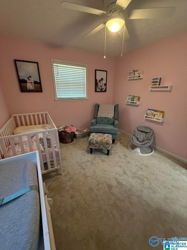 bedroom featuring a crib, carpet, and ceiling fan