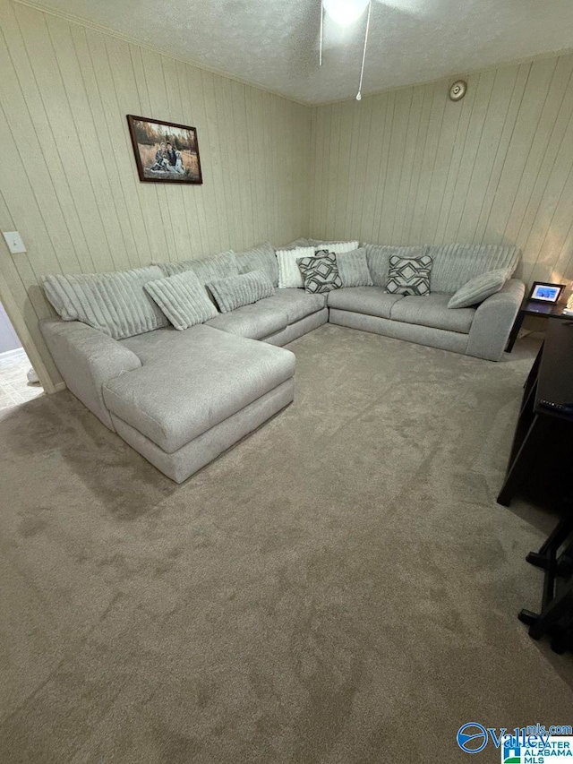 carpeted living room with wood walls and a textured ceiling