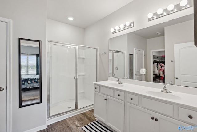 bathroom featuring a shower with door, wood-type flooring, and vanity