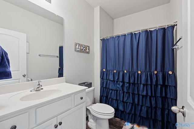 bathroom with wood-type flooring, walk in shower, vanity, and toilet