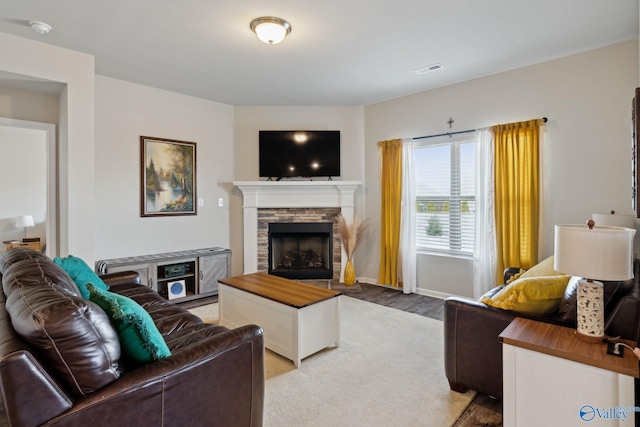 living room featuring hardwood / wood-style floors and a stone fireplace