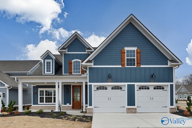 view of front facade featuring an attached garage, brick siding, board and batten siding, and concrete driveway