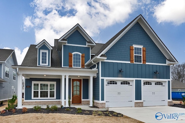 view of front of home with covered porch, driveway, brick siding, and board and batten siding