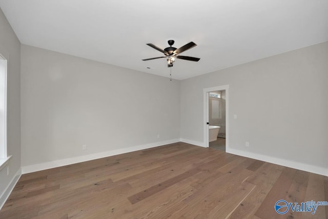 empty room featuring baseboards, a ceiling fan, and wood finished floors