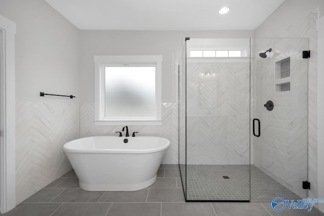 full bath with a shower stall, a freestanding tub, and tile patterned floors