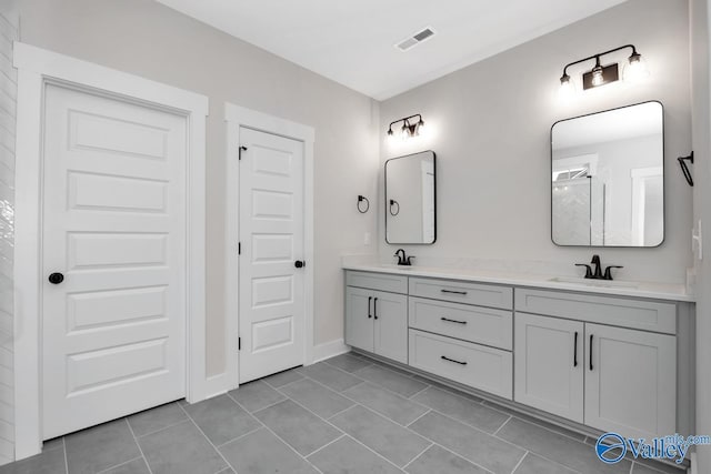 full bathroom featuring double vanity, a sink, visible vents, and tile patterned floors