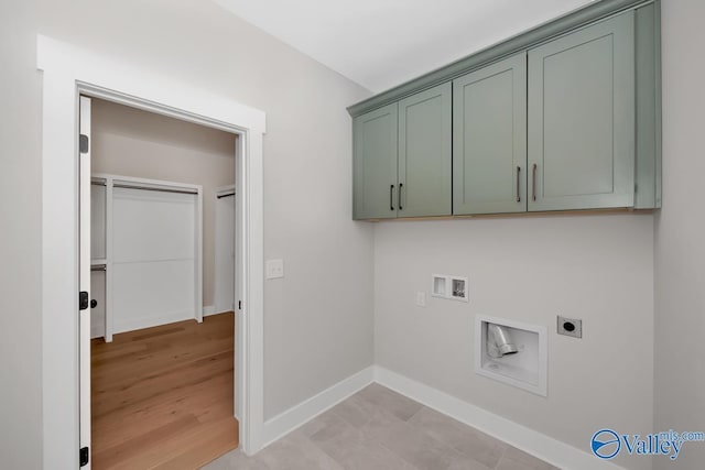 clothes washing area featuring hookup for a washing machine, cabinet space, electric dryer hookup, and baseboards