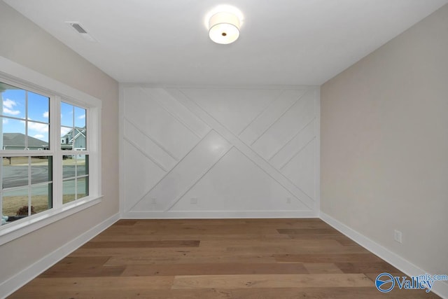 empty room with baseboards and wood finished floors