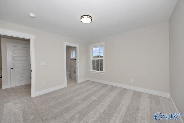 spare room featuring baseboards and carpet flooring