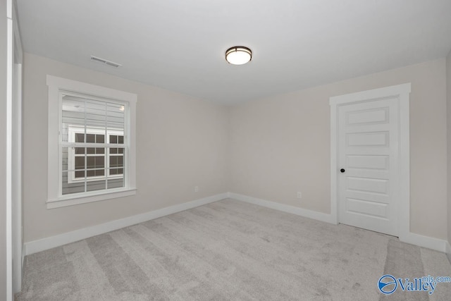 carpeted empty room featuring visible vents and baseboards