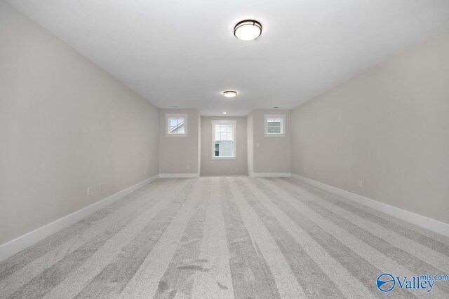 interior space with baseboards and light colored carpet