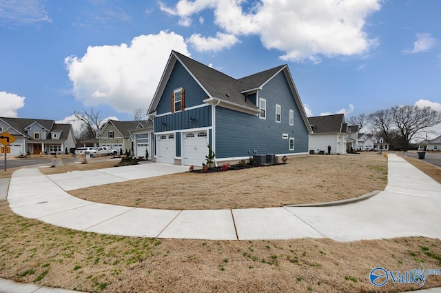 view of side of home featuring an attached garage, central AC, concrete driveway, a residential view, and board and batten siding