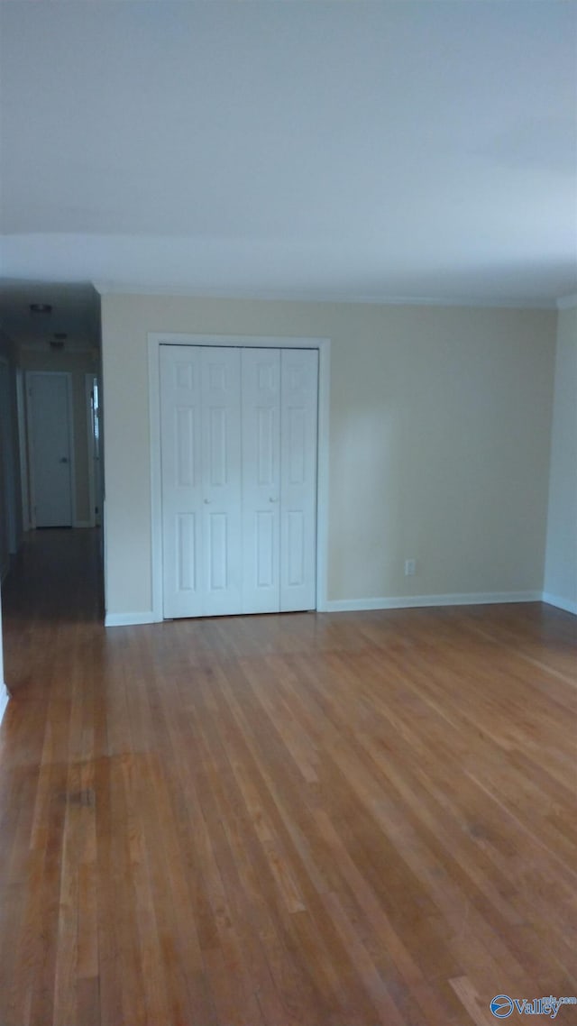 interior space featuring a closet, baseboards, and wood finished floors