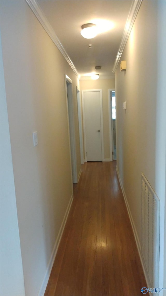 hall with visible vents, hardwood / wood-style flooring, baseboards, and ornamental molding