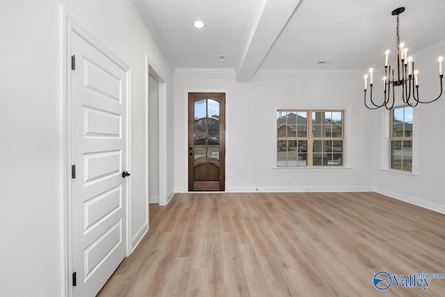 foyer entrance featuring an inviting chandelier, crown molding, and light wood-type flooring