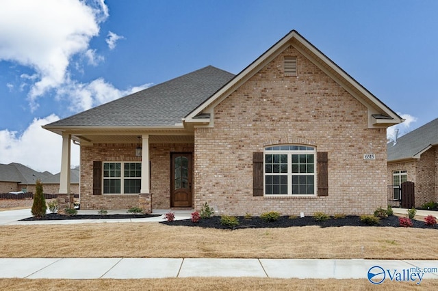 view of front facade featuring covered porch and a front yard