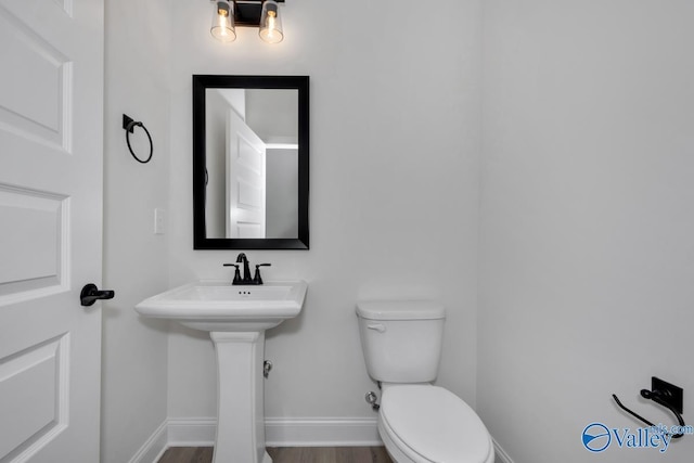 bathroom with hardwood / wood-style flooring and toilet