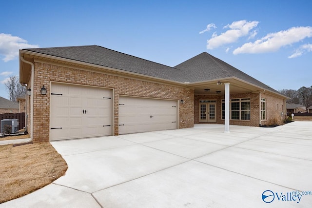 view of front of property featuring a garage, central AC, and french doors