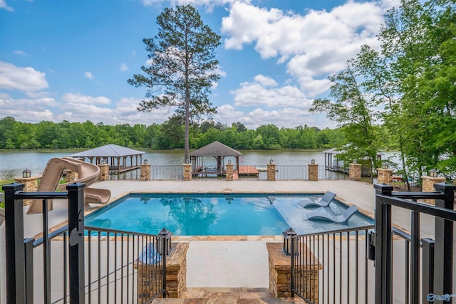 view of swimming pool featuring a gazebo, a water slide, a jacuzzi, a fenced in pool, and a water view
