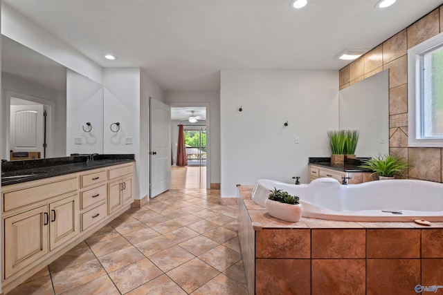 bathroom with a sink, tile patterned flooring, recessed lighting, and a tub to relax in