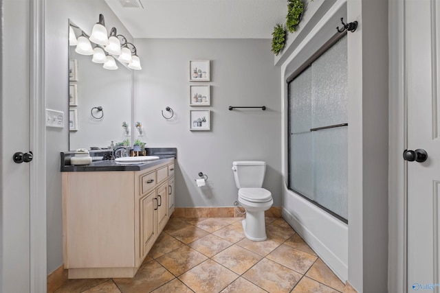 bathroom featuring tile patterned flooring, baseboards, vanity, bath / shower combo with glass door, and toilet