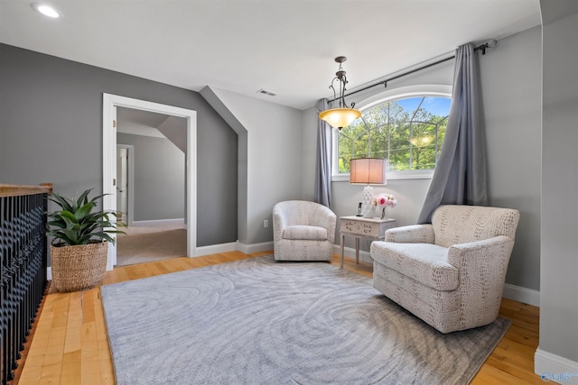 sitting room with baseboards, wood finished floors, and visible vents