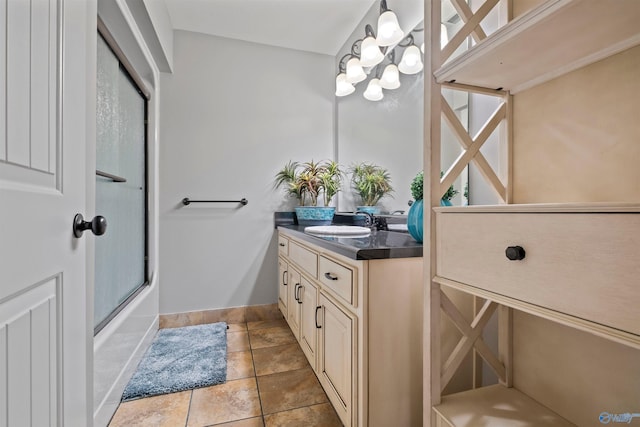 bathroom with vanity, baseboards, and shower / bath combination with glass door