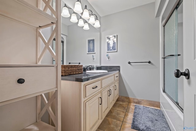 bathroom featuring vanity, bath / shower combo with glass door, and baseboards
