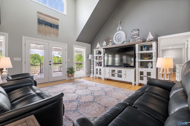 living area featuring wood finished floors, french doors, and a towering ceiling