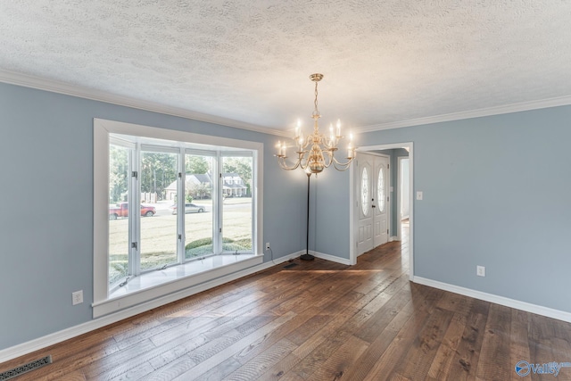 unfurnished dining area featuring dark hardwood / wood-style floors, a textured ceiling, an inviting chandelier, and ornamental molding