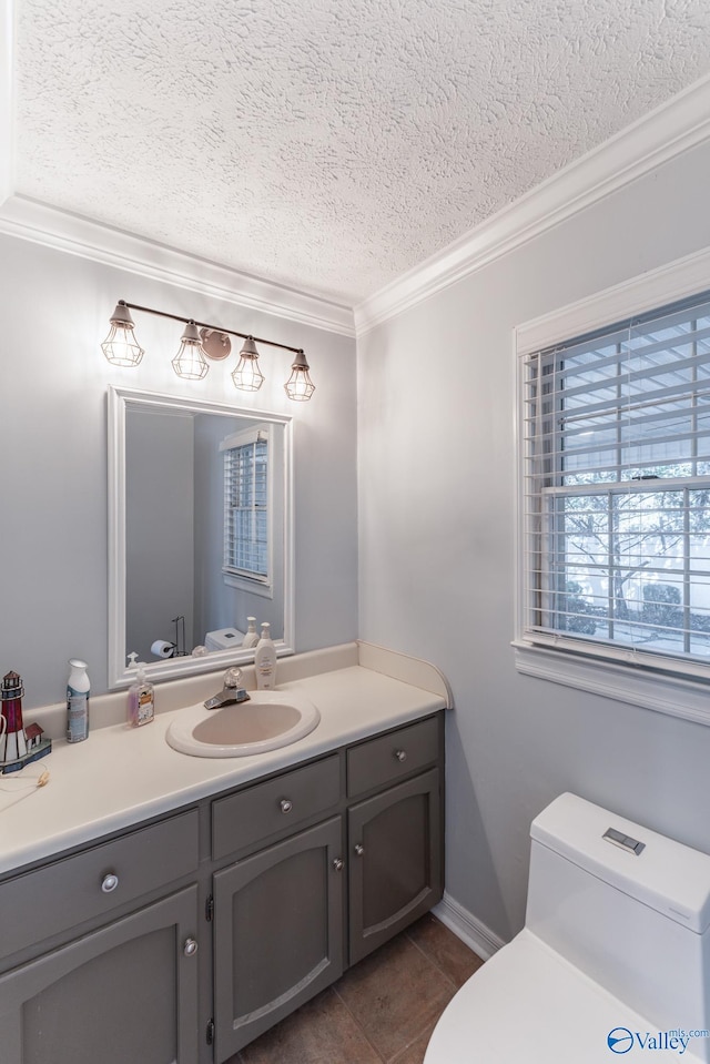 bathroom with ornamental molding, vanity, a textured ceiling, tile patterned flooring, and toilet