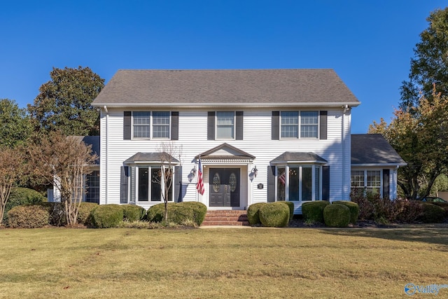 colonial house featuring a front lawn