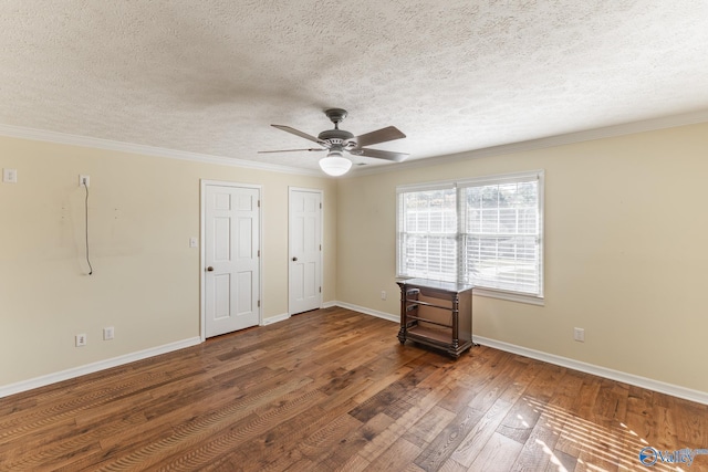 spare room with a textured ceiling, ornamental molding, dark hardwood / wood-style floors, and ceiling fan