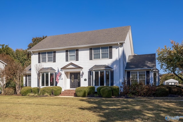 colonial-style house featuring a front lawn