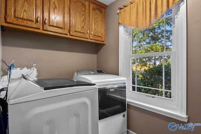 laundry room with separate washer and dryer and cabinets