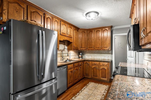 kitchen featuring backsplash, appliances with stainless steel finishes, ornamental molding, dark wood-type flooring, and sink