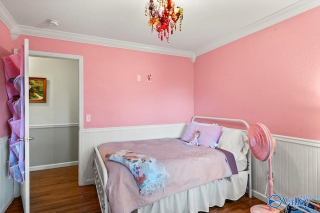 bedroom with wood finished floors, a wainscoted wall, and ornamental molding