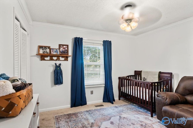 carpeted bedroom featuring a textured ceiling, ornamental molding, and a nursery area