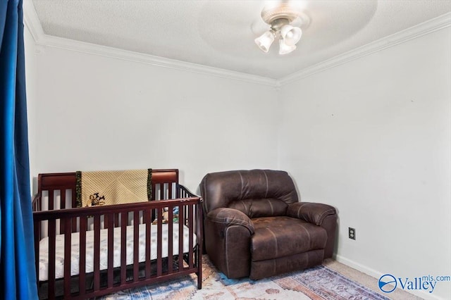 carpeted bedroom with ceiling fan, crown molding, a textured ceiling, and a crib