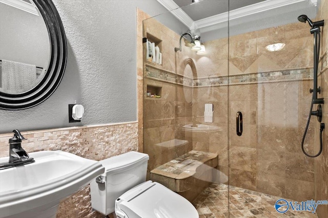 full bathroom featuring a shower stall, a wainscoted wall, toilet, ornamental molding, and a sink
