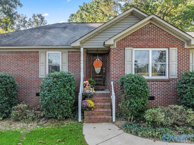 single story home featuring brick siding and roof with shingles