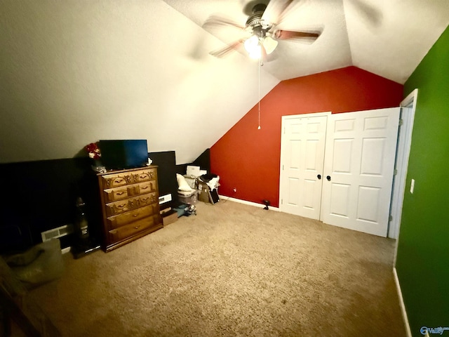 interior space featuring visible vents, carpet floors, ceiling fan, and vaulted ceiling