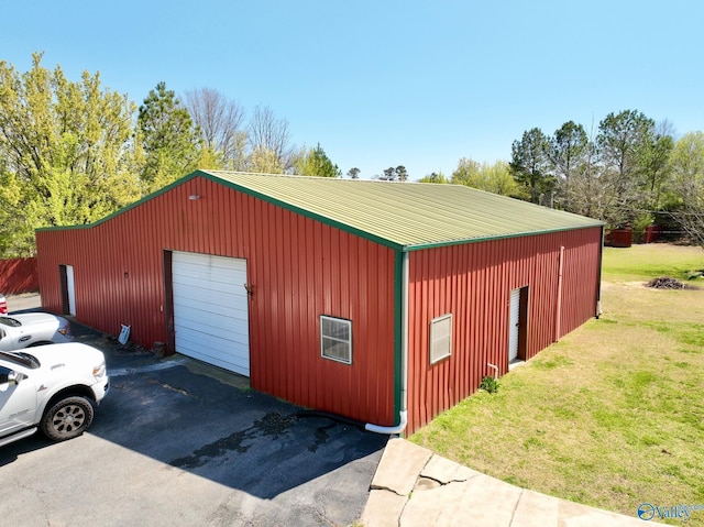 view of pole building with driveway and a yard