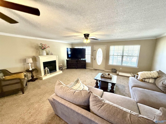 living room with a fireplace with raised hearth, ornamental molding, baseboards, light colored carpet, and ceiling fan