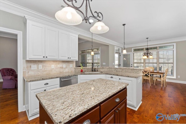 kitchen with dishwasher, a center island, a notable chandelier, pendant lighting, and white cabinets