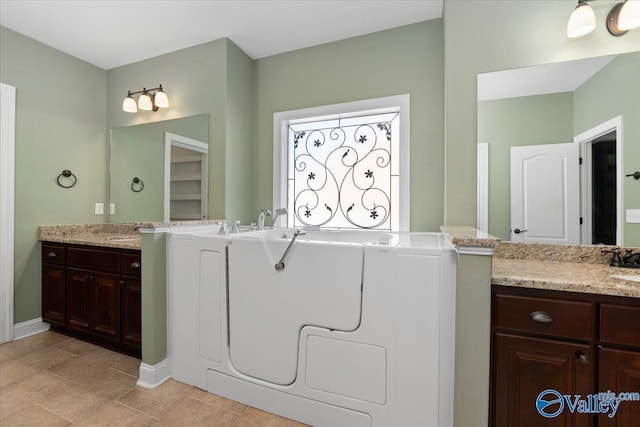 bathroom with a washtub and vanity