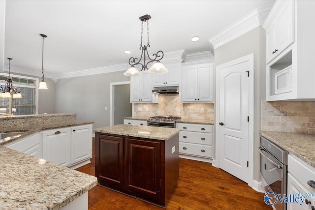 kitchen with a chandelier, a center island, white cabinetry, and hanging light fixtures