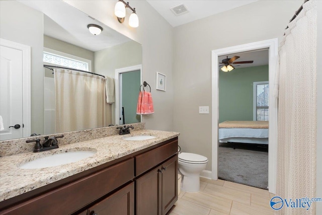 bathroom featuring vanity, tile patterned flooring, ceiling fan, toilet, and walk in shower